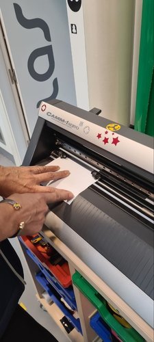 Placing the white vinyl sheet onto the machine bed.