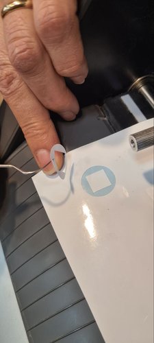 Weeded test cut on white vinyl showing a clean circle and square, used to check blade pressure.