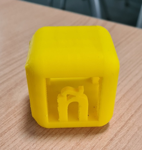 Final yellow cube with ñ letter visible inside, supports removed, printed on Bambu A1 Mini.