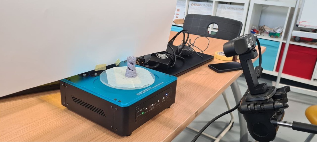 Turntable scanning setup with Elegoo curing station, white background, and Ferret scanner on tripod.