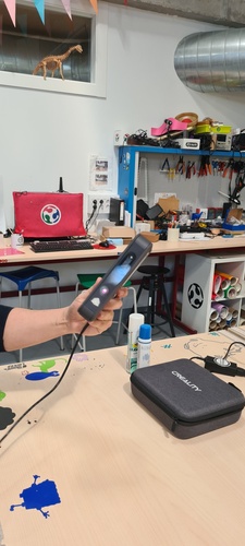 3D Sense scanner held in hand, powered on.