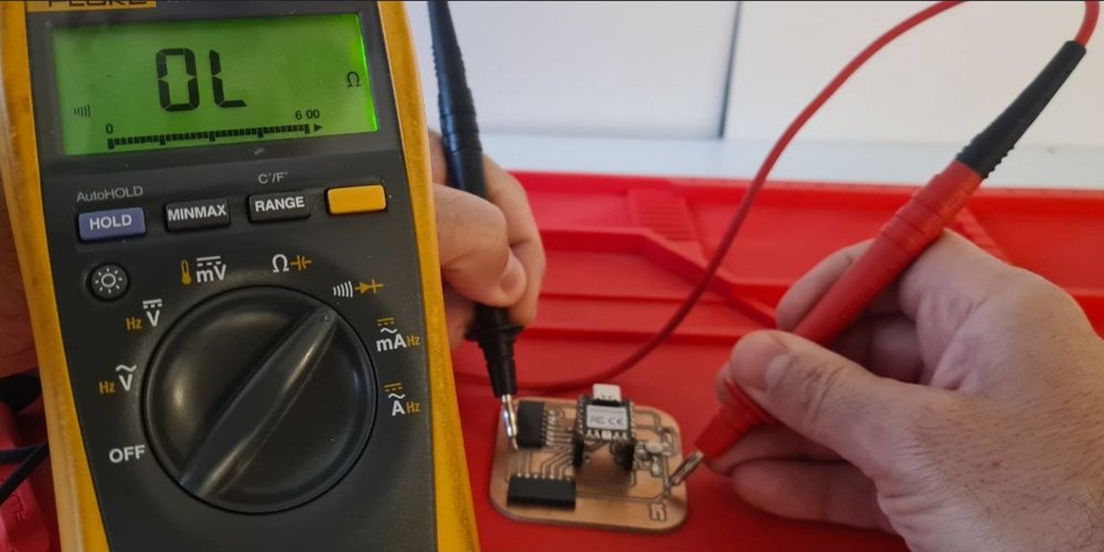 Fluke 179 in continuity mode reading OL while probing two unconnected points on the PCB.