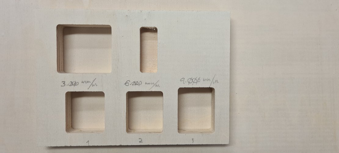 Test piece with three labeled areas — 3,000, 6,000, and 9,000 mm/min — written in pencil, with pocket cuts at each speed.