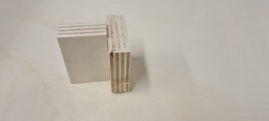 Second CNC tolerance test: two plywood joint pieces assembled, showing the fit result from a different angle.