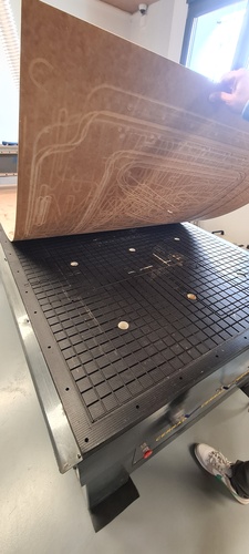 The vacuum table surface exposed, showing the black porous grid and the three circular suction ports.