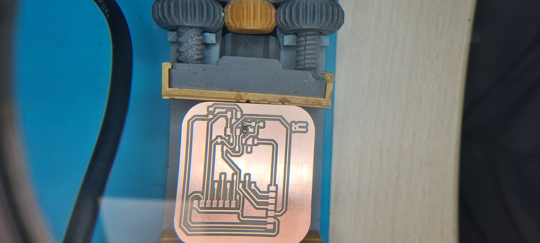 Milled PCB beside a pad of steel wool on a plastic sheet work surface.