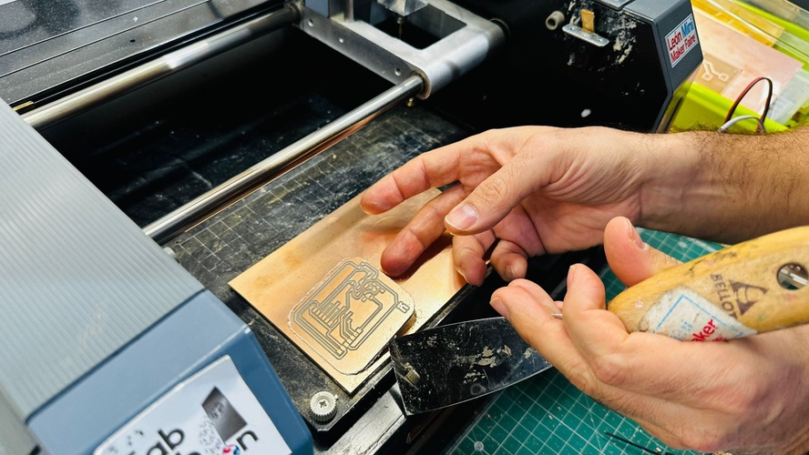 Milled board peeling off the sacrificial bed as the spatula travels underneath.
