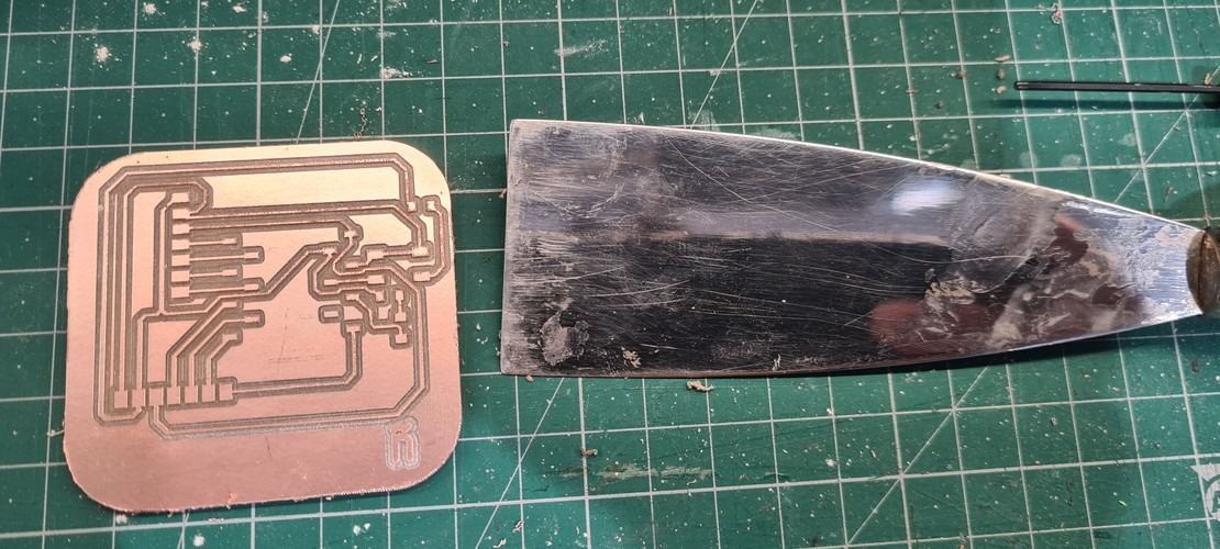 Spatula being used to lift milled PCB from MDX-20 sacrificial board after cutout pass.