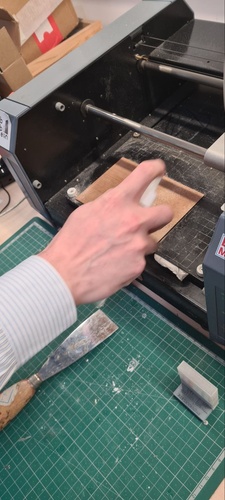 FR1 copper-clad blank held vertically against a ruler showing approximately 100mm height.