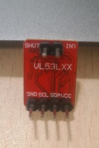 VL53LXX breakout module showing GND, SCL, SDA and VCC pins on the bottom edge and the sensor chip on the front face.