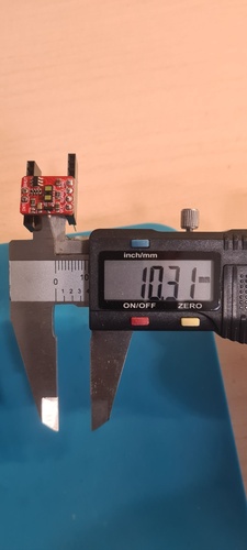 Digital caliper measuring the distance between the two pin socket groups on the VL53LXX breakout with sockets already inserted, reading 10.31 mm.