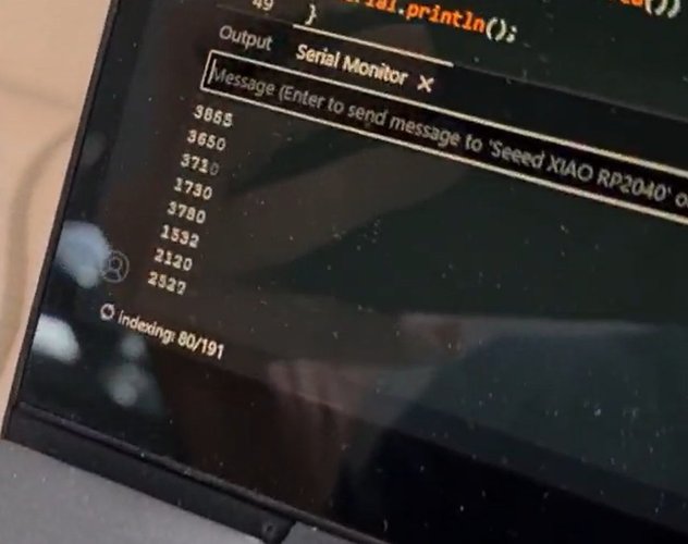 Arduino IDE Serial Monitor showing a column of distance readings in millimetres streaming from the Seeed XIAO RP2040.