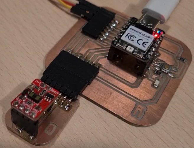 The VL53LXX time-of-flight breakout wired to the XIAO RP2040 board on the milled copper carrier, powered over USB-C with the XIAO's LED lit, running the distance sketch.