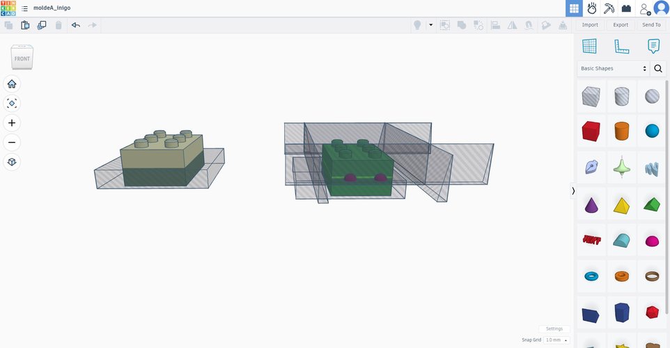 Front view in Tinkercad showing the inclined outer walls and the alignment pegs on the parting line, with the brick STL embedded inside the mould block.