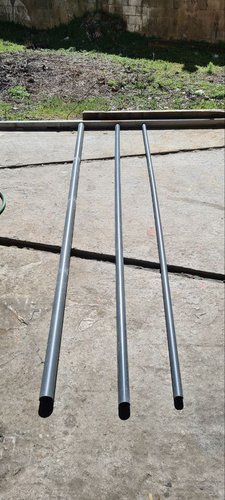 Three uncut PVC pipes of decreasing diameter (DN50, DN40, DN32) laid out on the workshop floor before cutting.