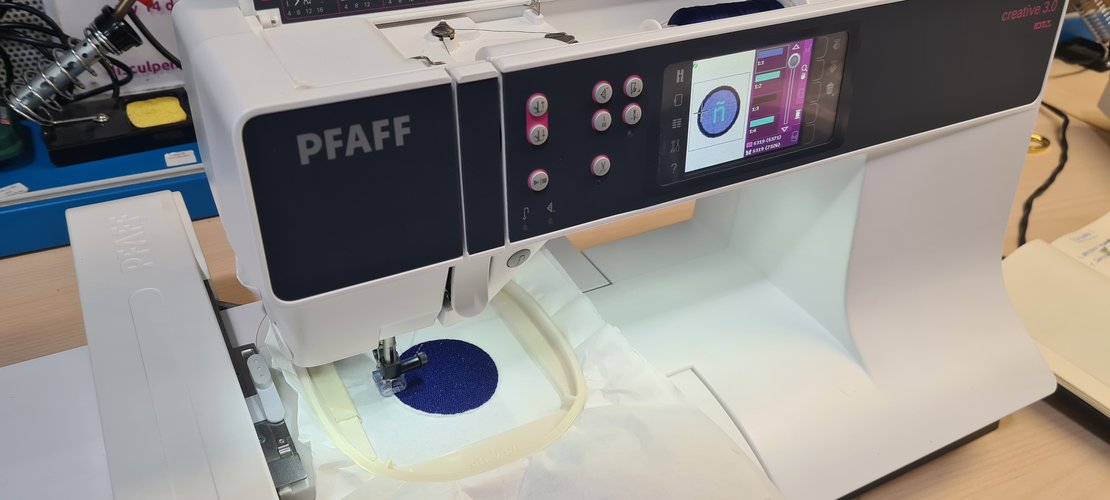 The blue circular fill being stitched, no letter or border yet, machine screen mid-block.
