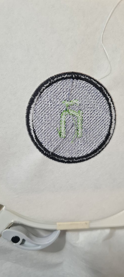 The back of the finished patch on the stabiliser: the bobbin-side stitching of the border, fill and ñ.