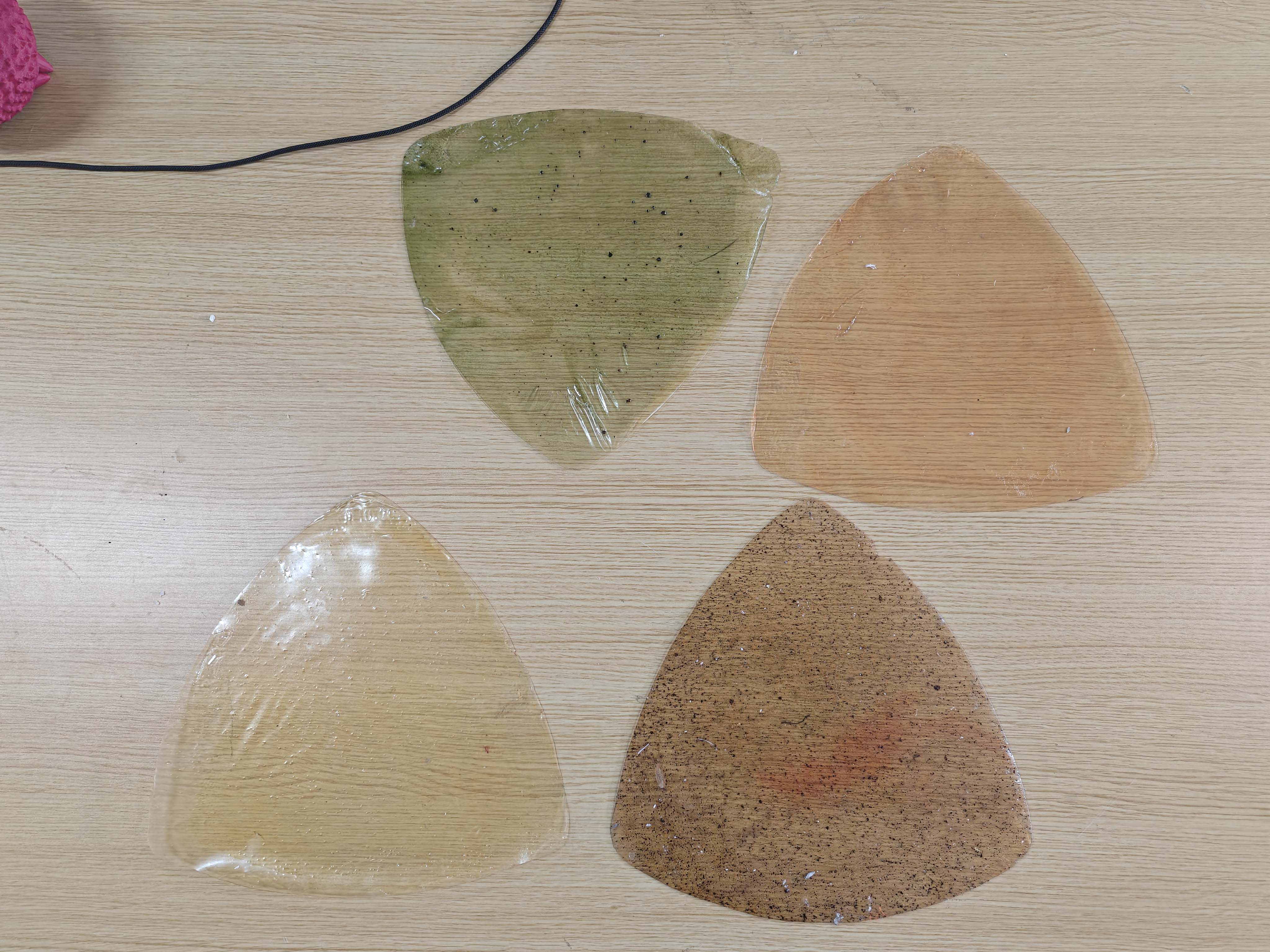 Four bio-material sheet samples with different colors and textures