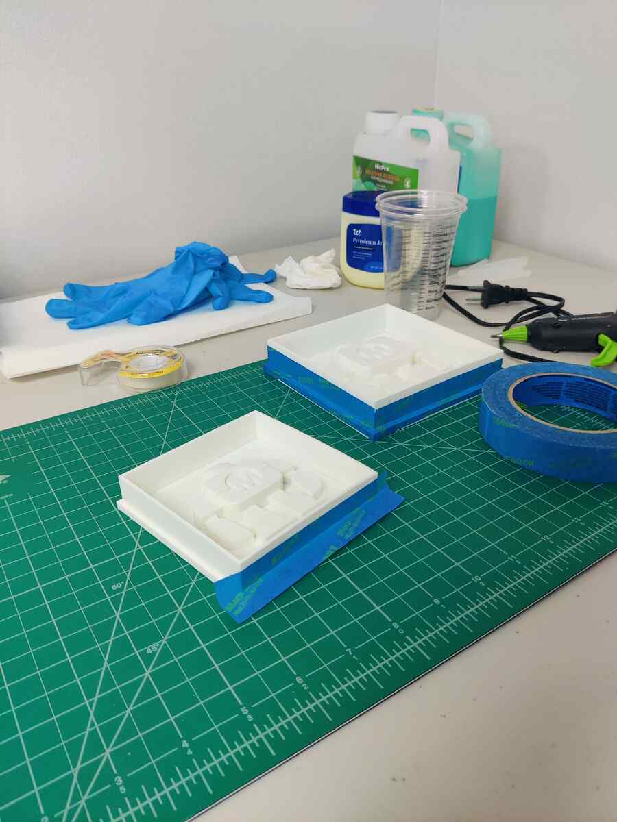 Two prepared mold boxes sealed with blue tape, ready for pouring