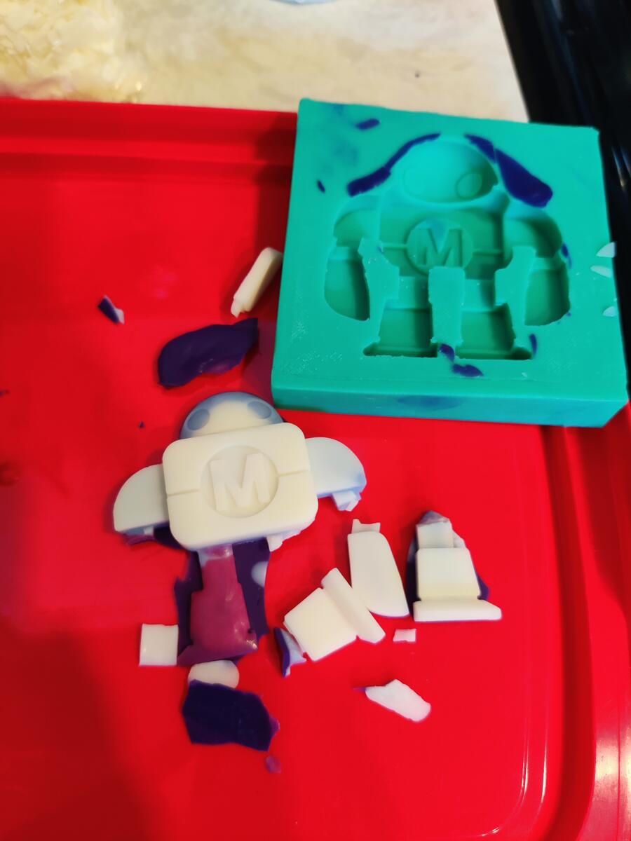 Broken soap cast pieces next to the silicone mold after first attempt