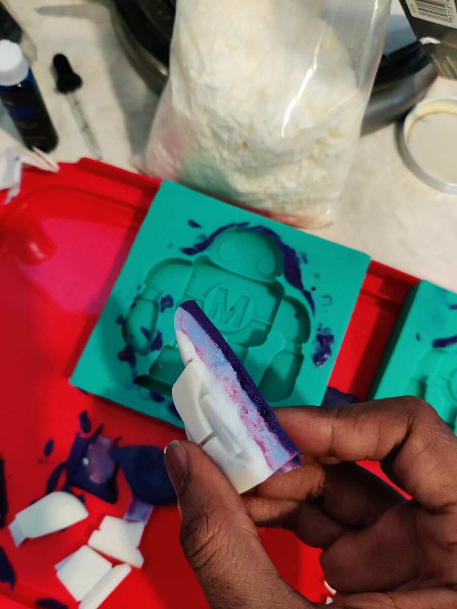 Close-up of a broken cast piece showing white and purple layered colors