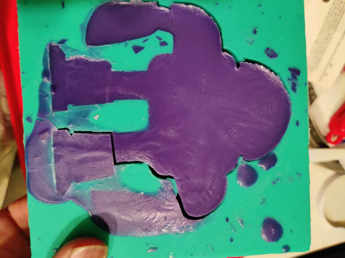 Purple wax/soap cast of the robot shape in the silicone mold