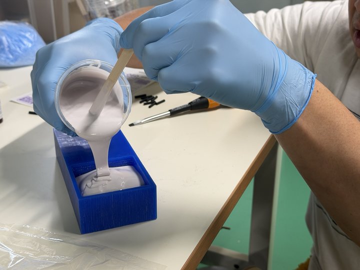 Pouring silicone into wax mold