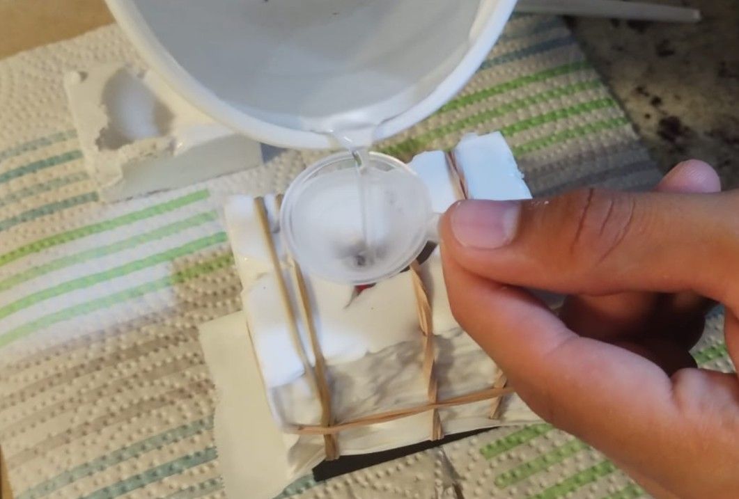 Pouring wax into the mold with a funnel