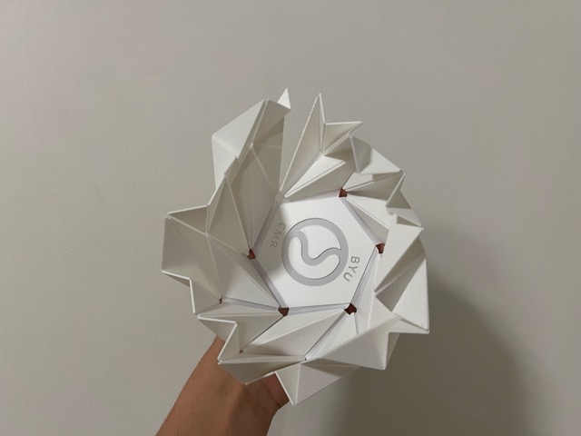 3D printed flasher hexagon with living hinges showing small tears at the fold lines and a broken side after repeated folding cycles