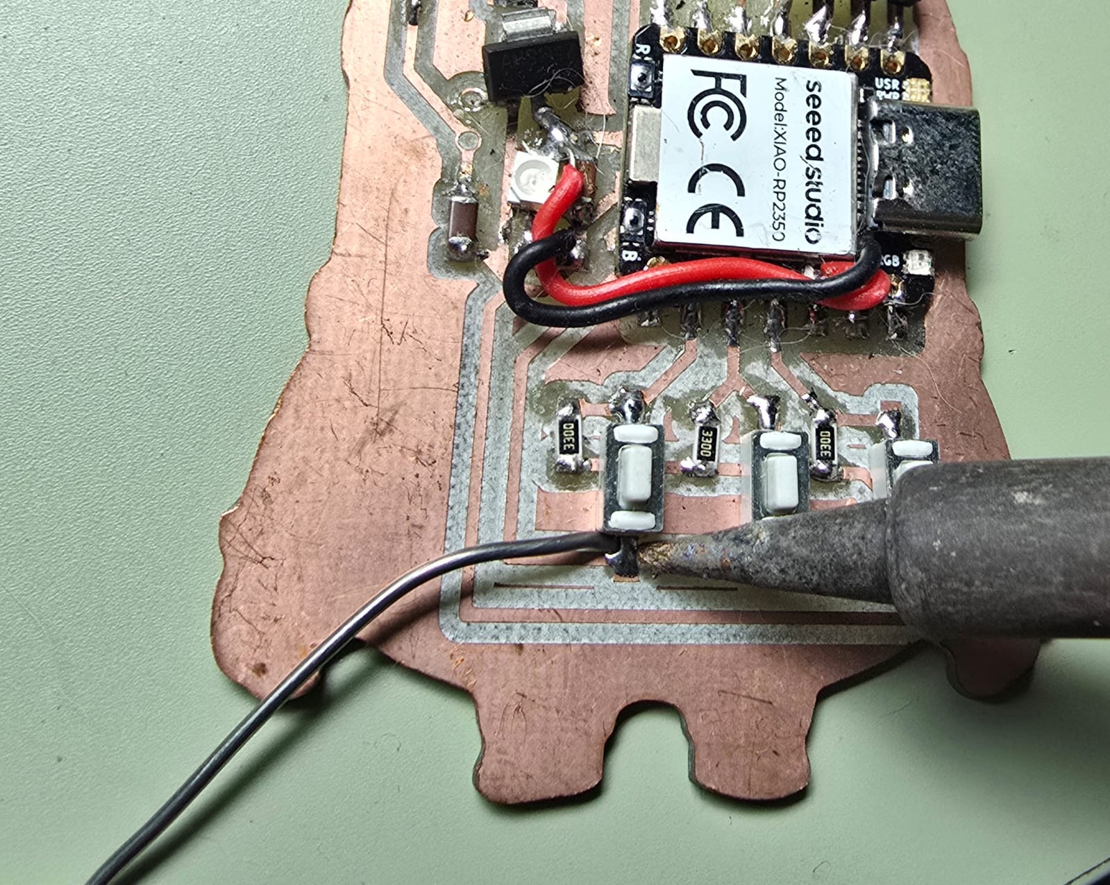Soldering the XIAO RP2350 and 330 ohm resistors on the milled copper board