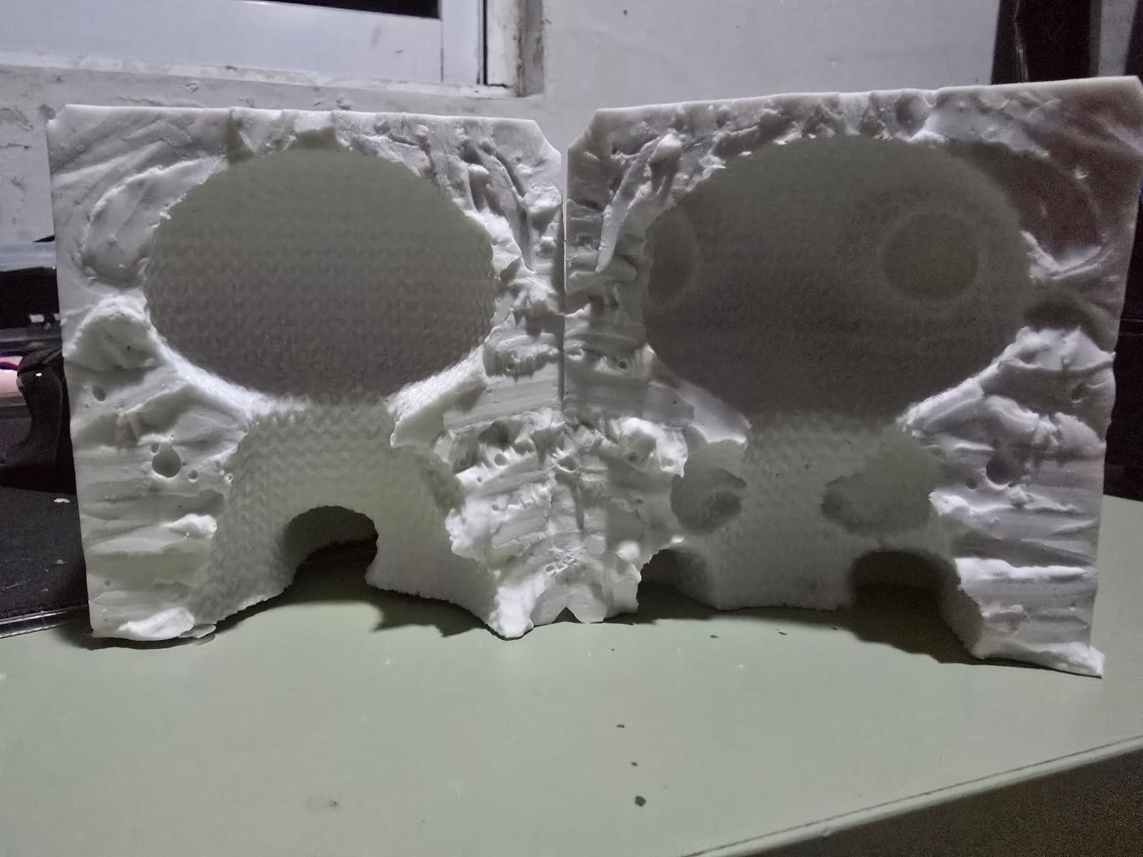 The two halves of the silicone mold cut through the neck, showing the cavity and registration locks