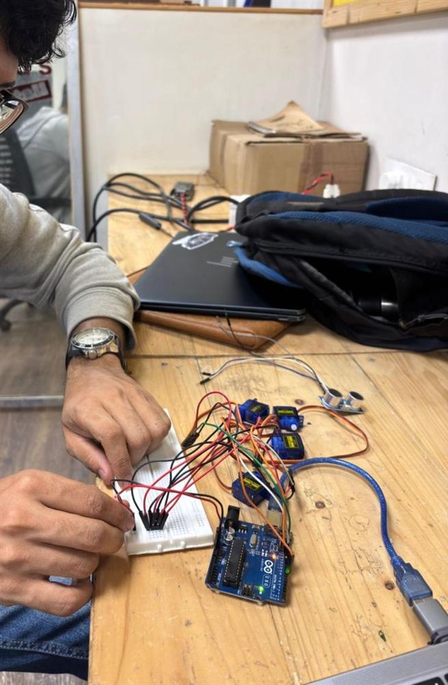 Wiring four servo motors and an HC-SR04 ultrasonic sensor to an Arduino Uno on a breadboard