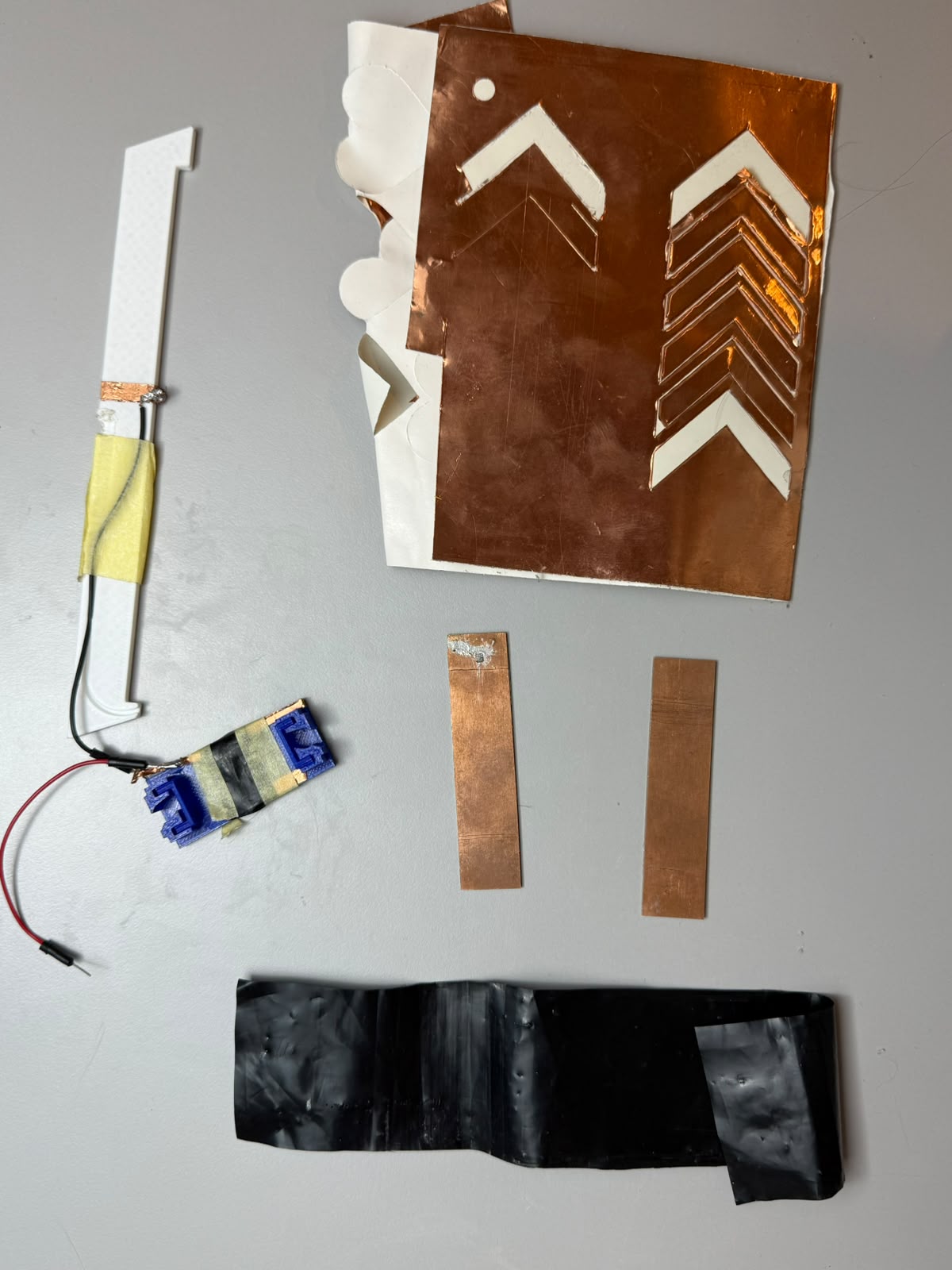 Sensing material candidates: Velostat sheet, copper tape busbars, conductive steel wire, and conductive PLA sample