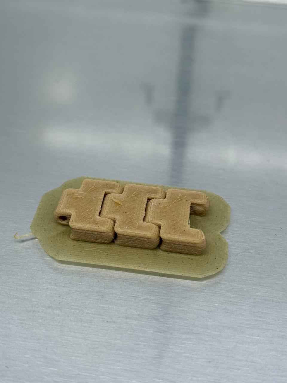 The completed multi-material, flexible interlocking link assembly successfully printed and removed from the build plate.