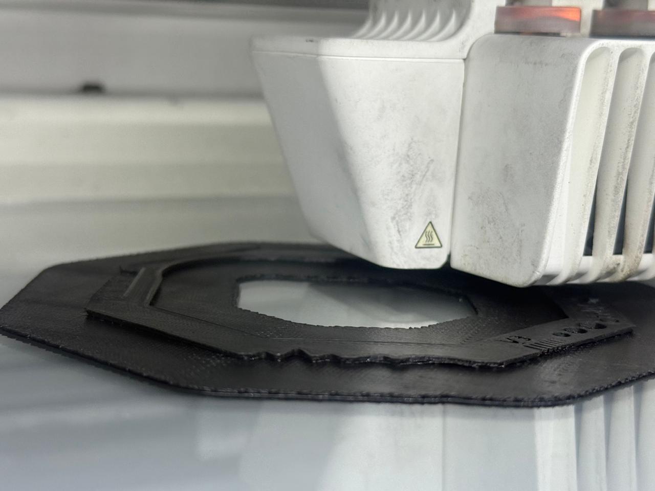 3D print in progress on the heated glass bed with the print head active