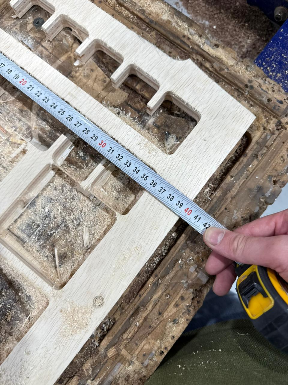 Inspecting raw sheet of 18mm plywood aligned on the ShopBot CNC bed table