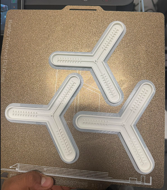Three 3D printed PLA molds on print bed
