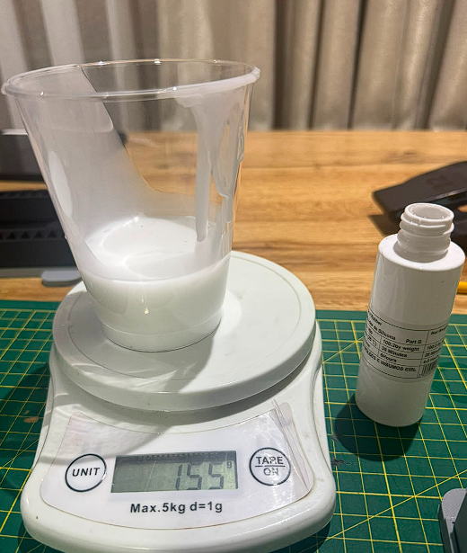Scale at 155g after adding catalyst, bottle visible