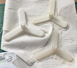 Two finished silicone tentacle actuators on paper after second cure