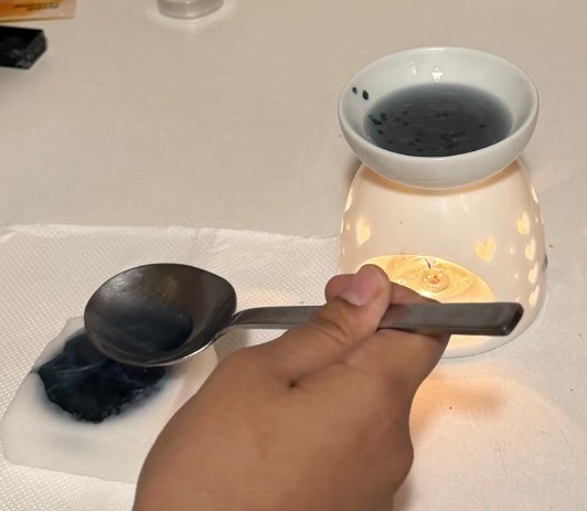 Spooning melted blue wax into mold cavities