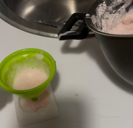Using a funnel to precisely pour soap into the silicone mold