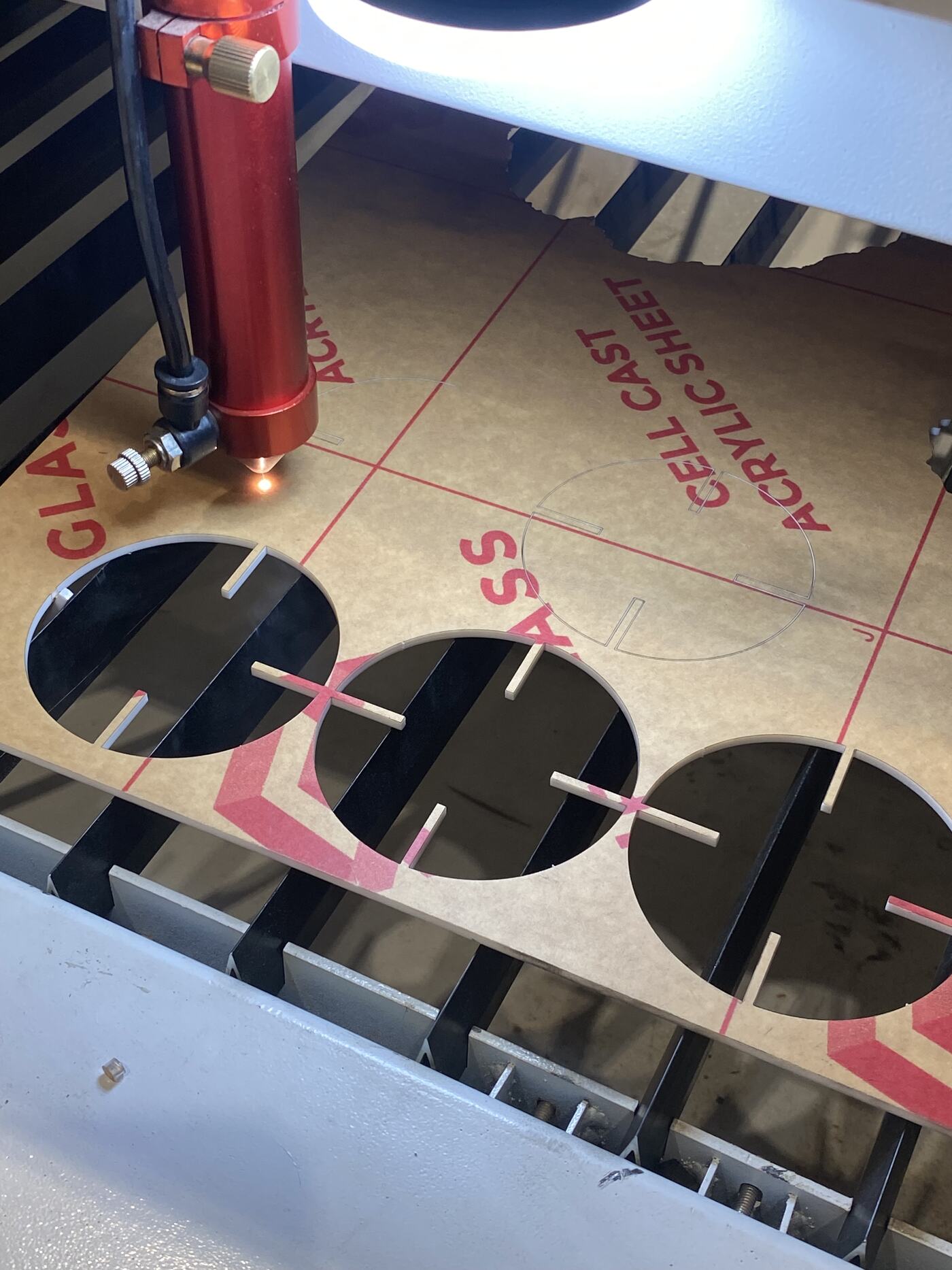 Laser cutter cutting the construction kit pieces from the 3mm acrylic sheet