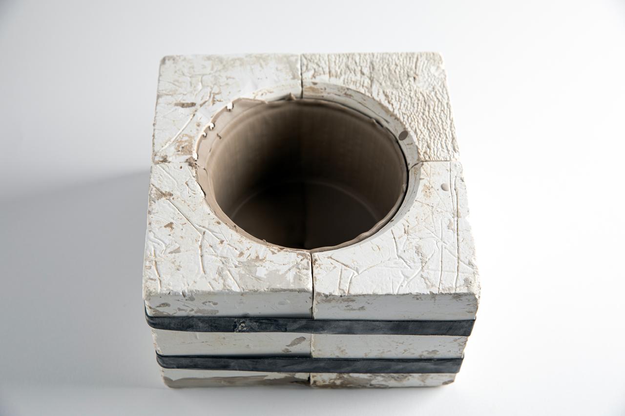 Mold filled with slip, sitting to build clay wall
