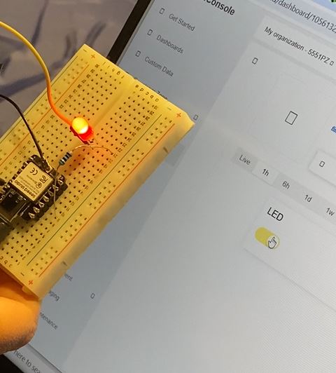 ESP32 board with LED lit, Blynk dashboard open showing switch ON