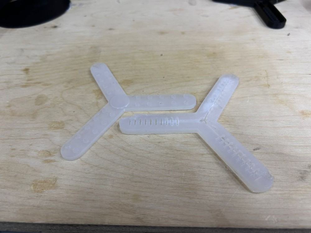 Two demolded silicone gripper halves showing the internal channel structure and clean surface finish