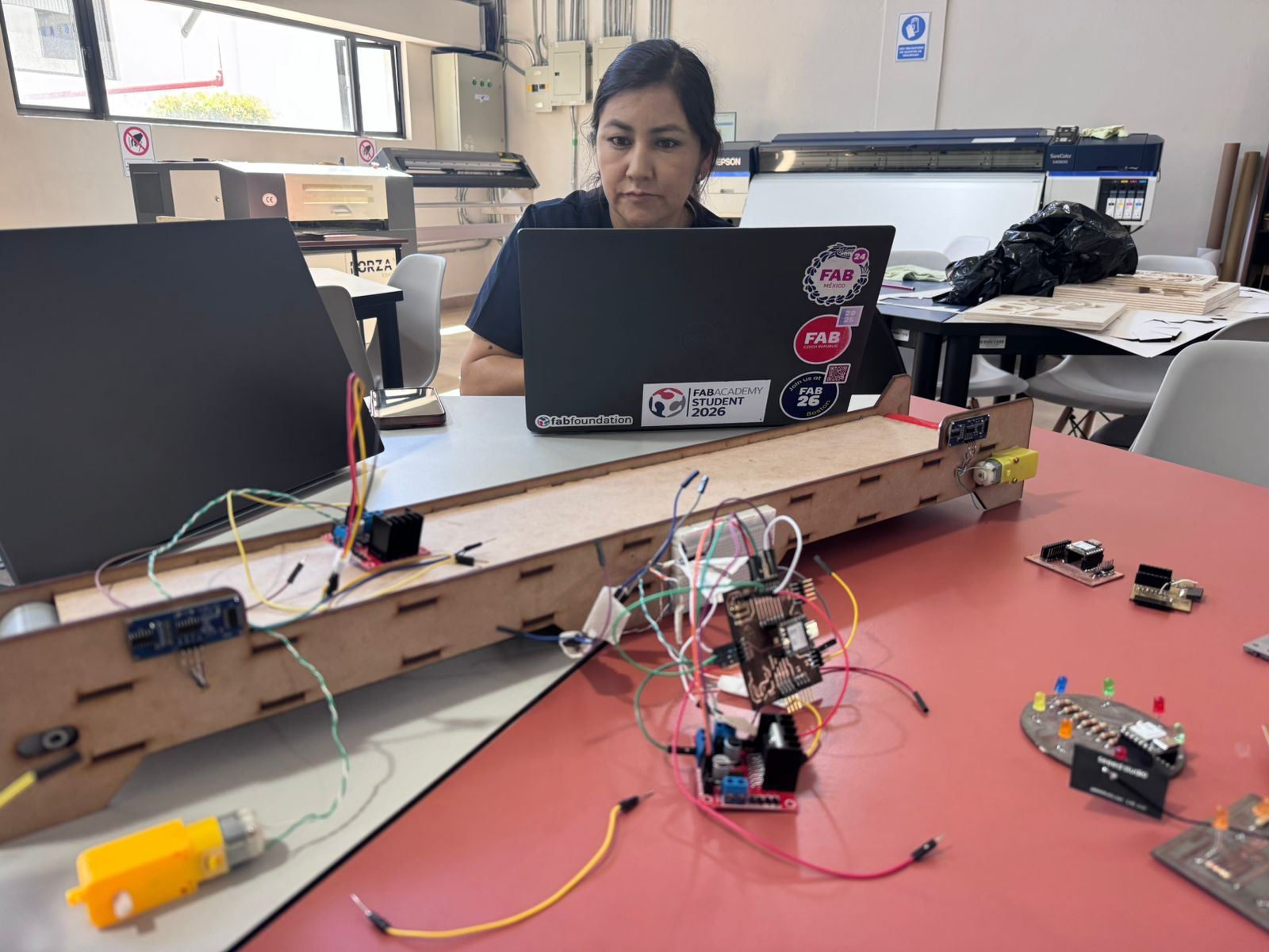 Jenny adjusting wires and soldered connections on the conveyor belt system